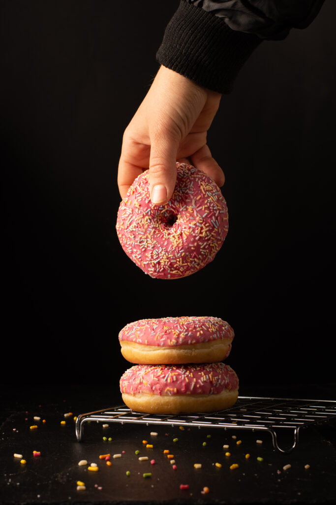 Super Donuts on a wooden tray with a light glaze, served with coffee and fresh fruit.