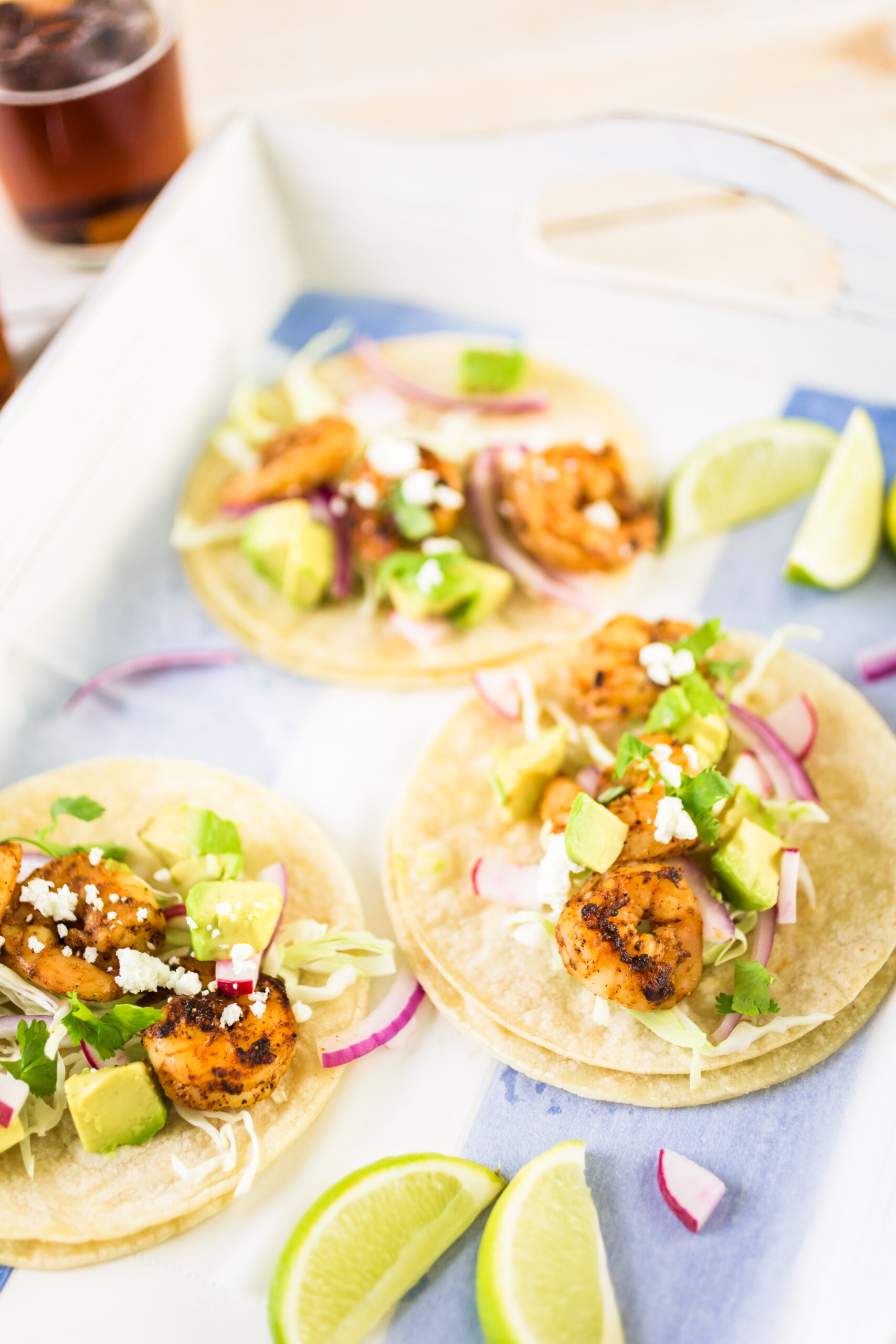 Crispy air fryer fish tacos served with shredded cabbage, pico de gallo, and lime crema on soft tortillas, garnished with fresh lime slices and cilantro.