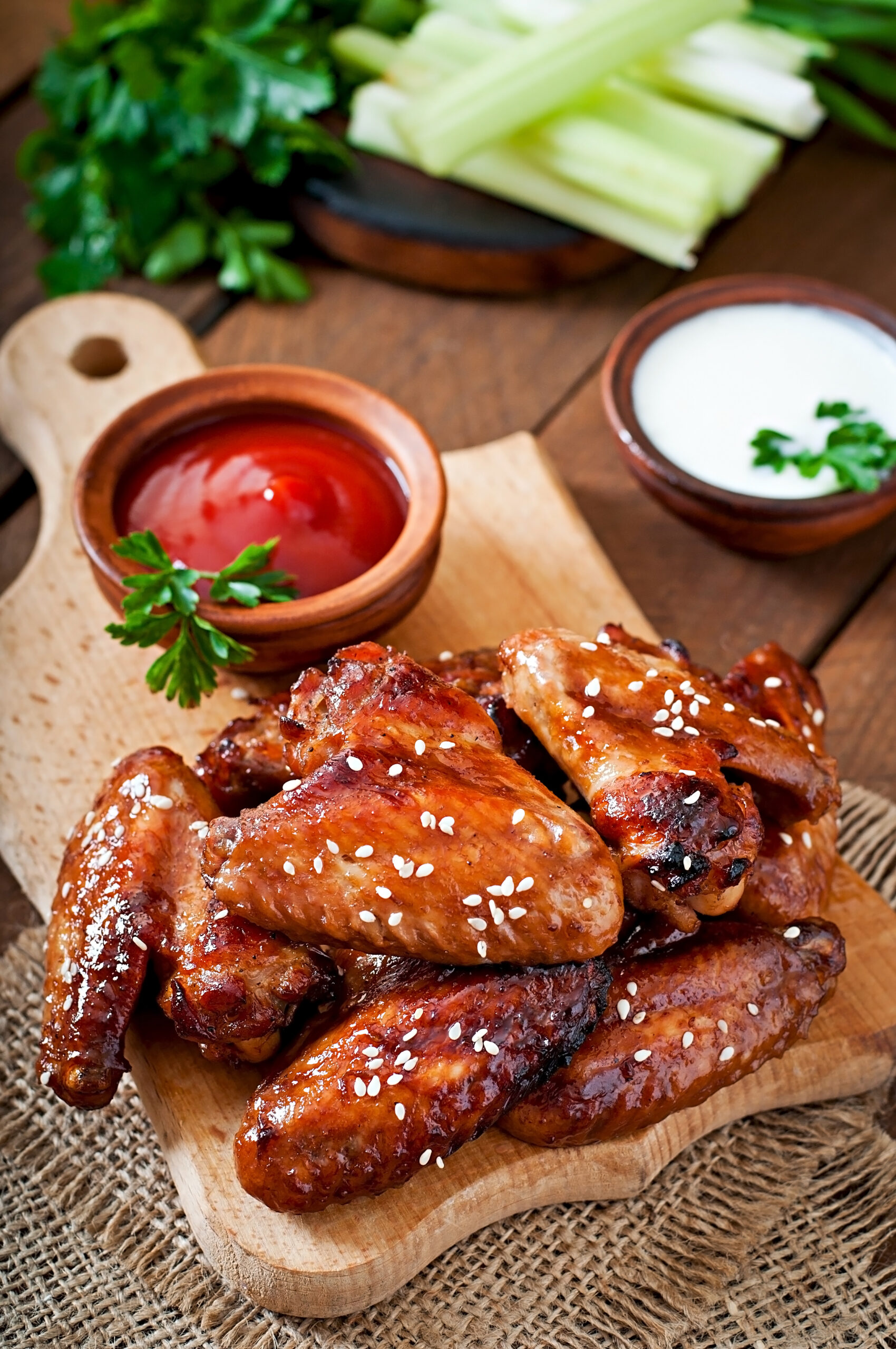 Crispy honey buffalo wings served on a platter with celery sticks and a side of ranch dressing.