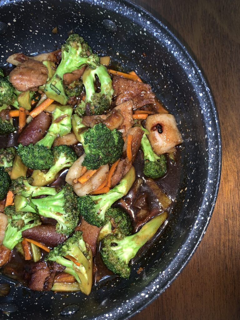 A vibrant plate of stir-fried frozen vegetables with broccoli, carrots, and snap peas garnished with sesame seeds.