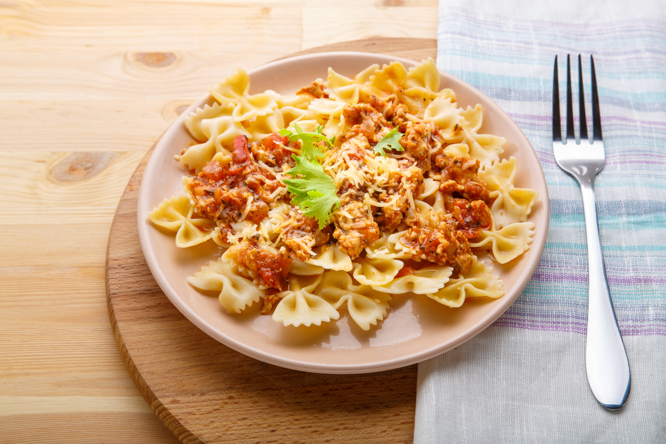 A steaming bowl of cheeseburger macaroni with creamy cheese sauce, ground beef, and pasta, topped with fresh parsley for a comforting and hearty meal.